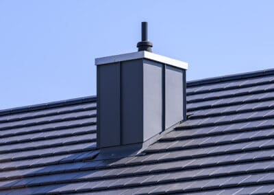 Dachumdeckung mit Außendämmung und Schornstein mit Stehpfalztechnik